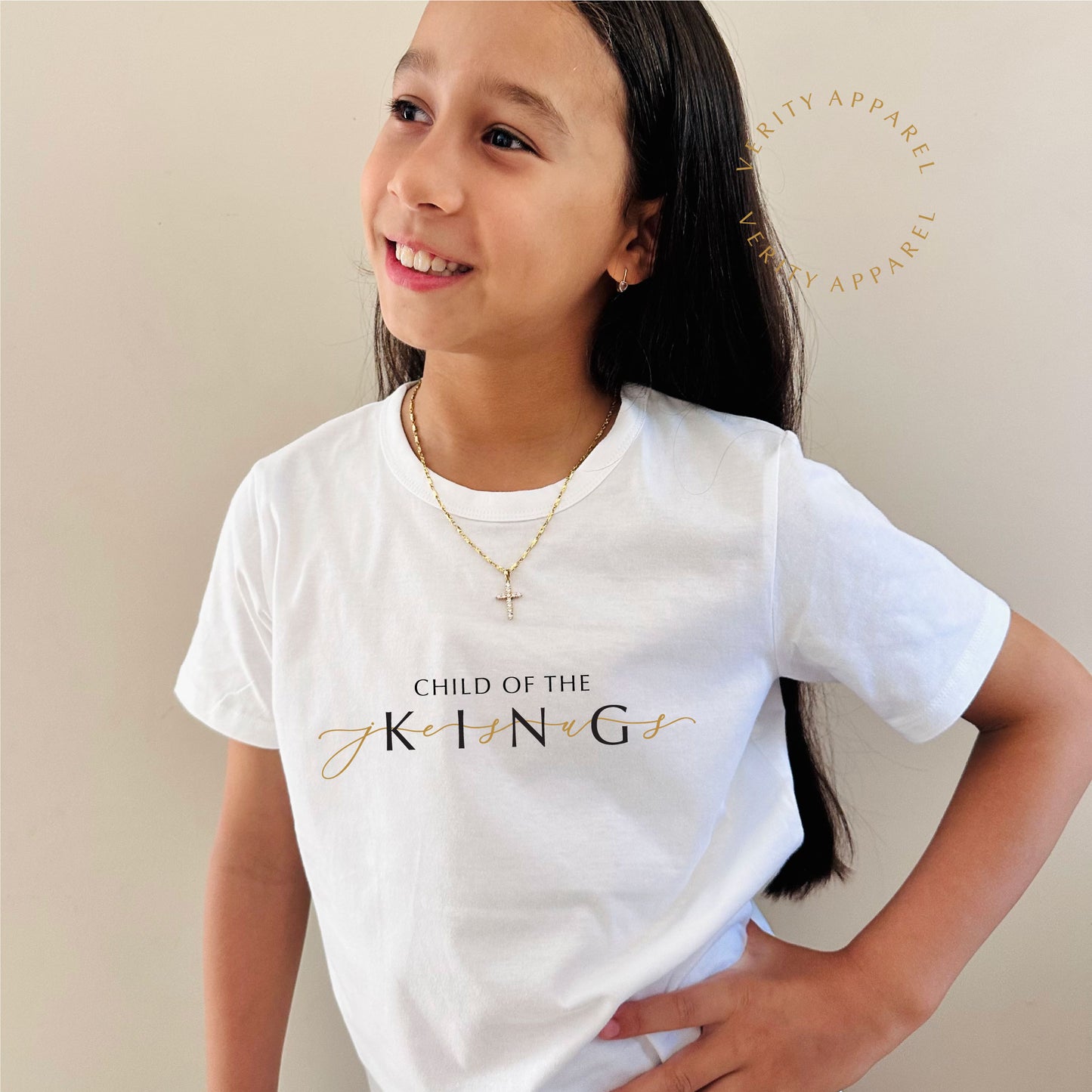 Young girl wearing 'Child of the King' christian kids tee in white cotton. The design features the word Jesus in gold weaved through the design.