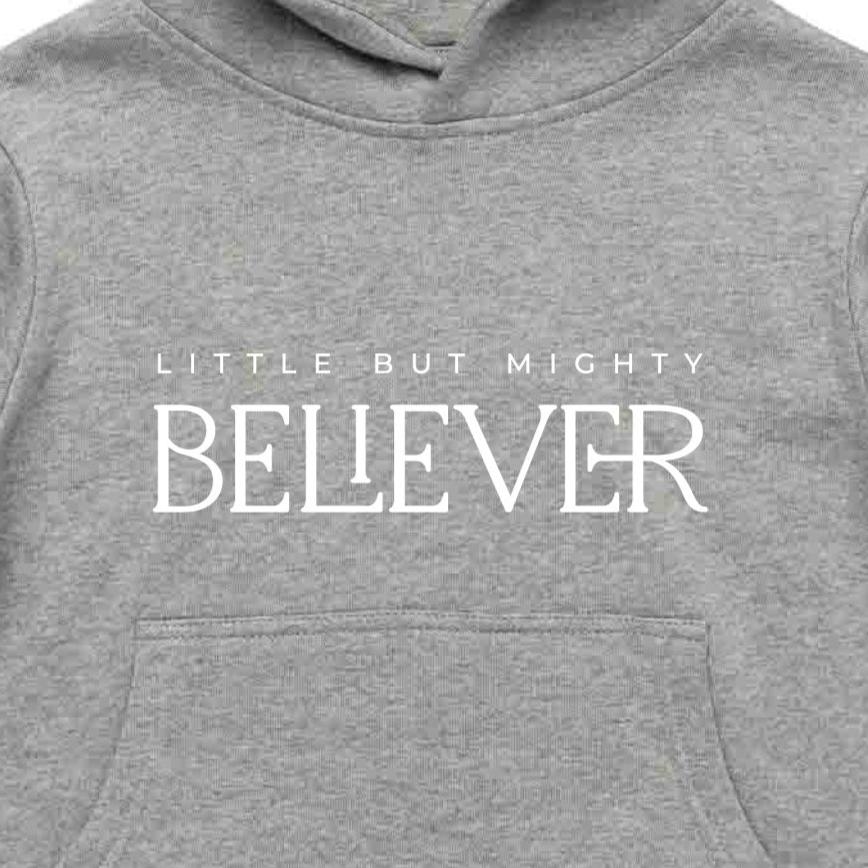 Close up of a grey kids Christian hoodie with "Little but mighty Believer" print on it in white.