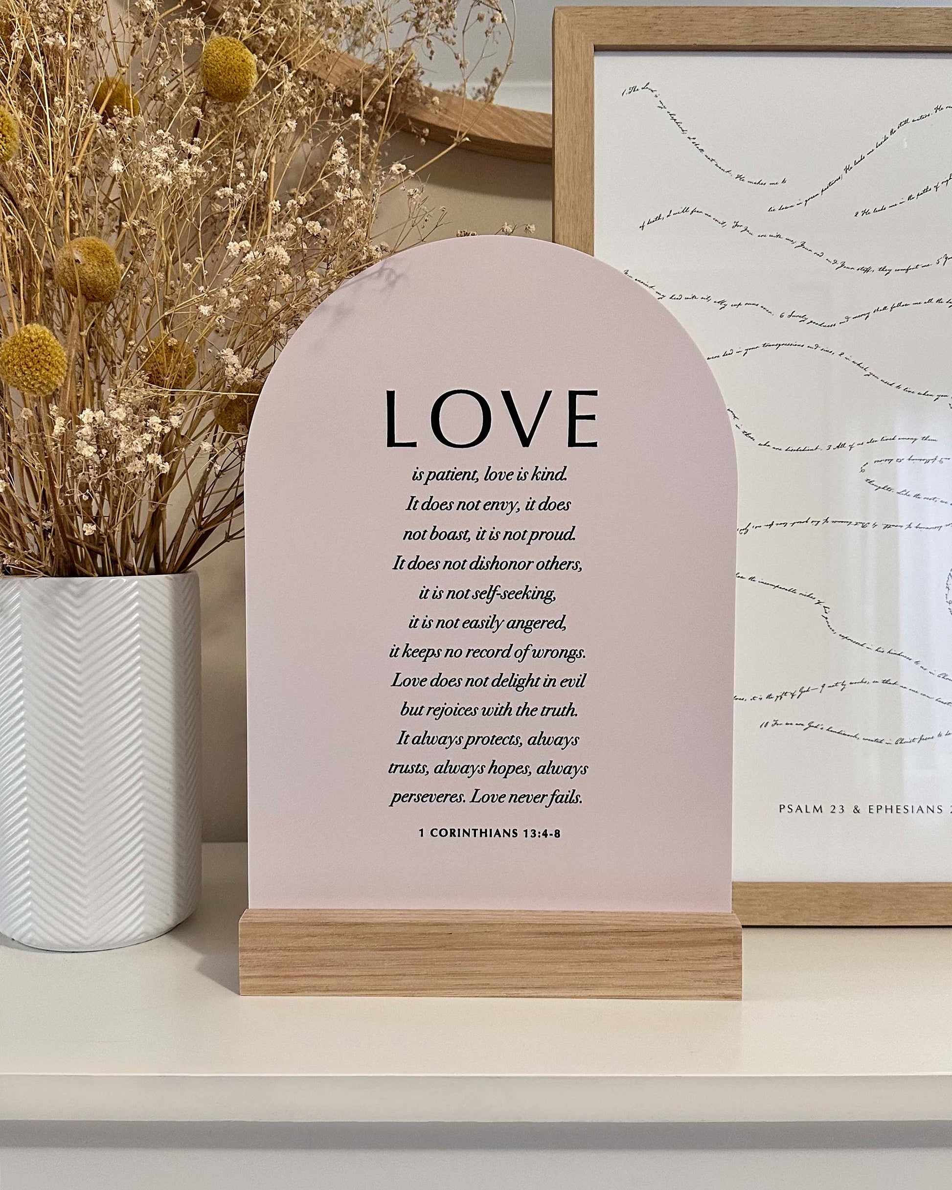 Decorative sign with 'LOVE' text on a shelf with decorative elements